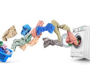 Clothing flies out of the basket into the washing machine isolat