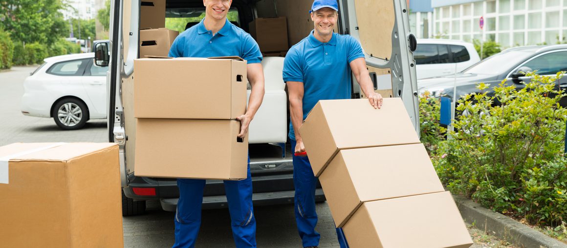 Two Workers Loading Cardboard Boxes In Truck